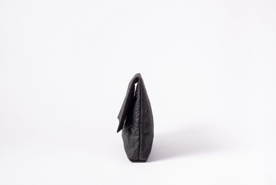 Side view on an upstanding charcoal colored Clutch with invisible magnet opening
